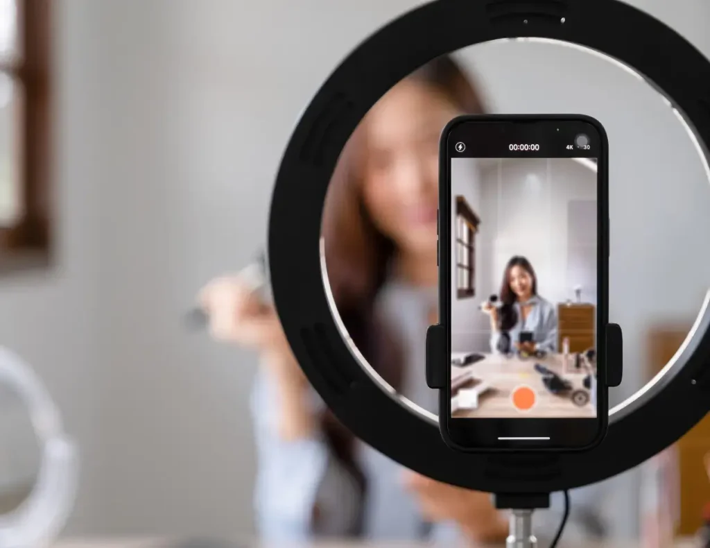 Influencer records a video via smartphone positioned on ring light for the Content Marketing service of the Digital Agency Jinni S.r.l.