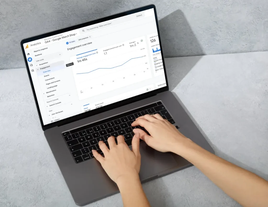 Hands typing on a laptop with Google Analytics open on the screen for the service of Digital Agency Jinni S.r.l.